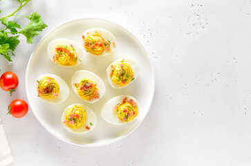 Stuffed eggs with egg yolk, bacon and dill