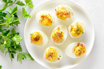 Stuffed eggs with egg yolk, bacon and dill