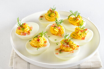 Deviled stuffed eggs with egg yolk, bacon and dill