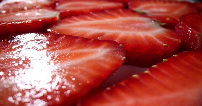Fresh glistening strawberry slices arranged meticulously. Vibrant red color and juicy texture of berries forming appealing visual pattern