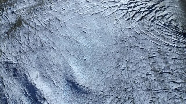 Aerial view of majestic Morteratsch Glacier with ice crevices and pristine alpine landscape, Pontresina, Switzerland.