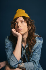 Naklejka premium Handsome young man showcasing trendy fashion and unique style with a yellow hat