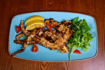 Grilled octopus with lemon on plate 