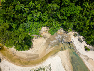 Birds eye view of a jungle river surrounded by lush, dense tropical rainforest