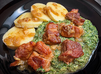 Detail shot of spinach, roast pork and potato dumplings