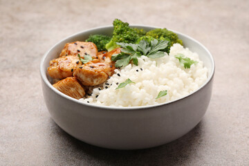 Tasty rice with broccoli, chicken and parsley on grey table, closeup