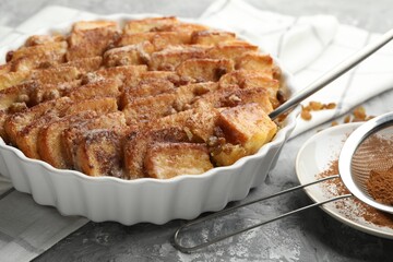 Delicious bread pudding with raisins and cinnamon on grey table, closeup