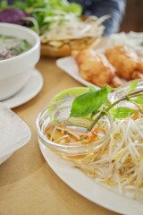 A plate of sugarcane prawns, fresh bean sprouts, nuoc cham sauce, basket of fresh herbs for rice paper rolls and pho at Phu Quoc, a Vietnamese-Chinese restaurant in Cabramatta - Sydney, Australia 