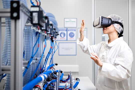 Mechatronics engineer using VR glasses to visualize prototype machine in research and development factory.