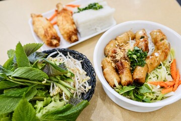 A plate of sugarcane prawn rolls (chao tom) and a bowl of bun cha (combination vermicelli noodle bowl with spring rolls) at a Vietnamese restaurant in Cabramatta, Sydney — New South Wales, Australia
