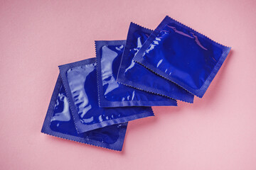packaged condom on pink background contraception concept