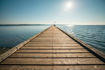 Fototapeta premium Wooden pier stretching into the distance with sunlight reflecting off its surface, pier, outdoor, scenery