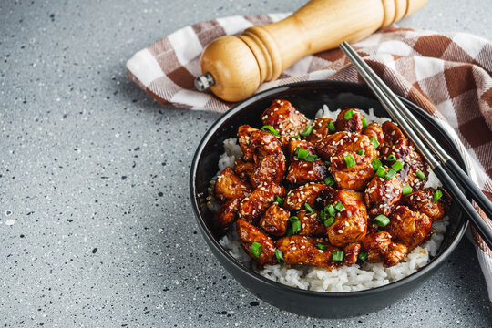 delicious juicy Japanese teriyaki chicken on rice on a gray background