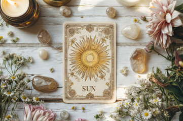 Sun tarot card surrounded by crystals and flowers on a wooden surface during daytime ceremony