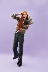 Stylish young queer man expresses joy with red hair and modern fashion on a pastel background