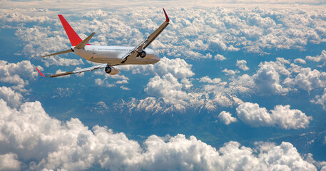 An airplane flying over a taurus mountain range, with snow-capped peaks visible below