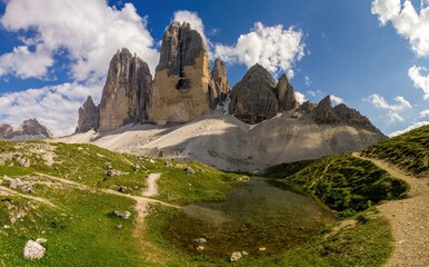Hiking trail and mountain lake in the Italian Dolomites. Stunning view of the Tre cime di Lavaredo during a beautiful day. Drei Zinnen of Lavaredo symbol of the Dolomites, Trentino, Südtirol.
