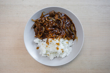A plate of rice with beef curry.