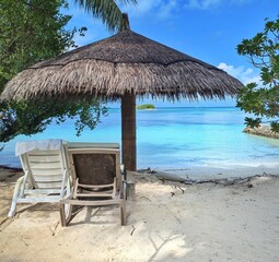 A tropical beach in the Maldives with a cozy palm hut, white sand, and crystal-clear waters.