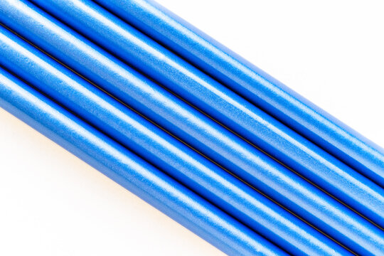 A neatly arranged set of blue pencils lies on a white surface, their sharpened tips pointing in the same direction. The image evokes creativity, precision, and artistic inspiration.

