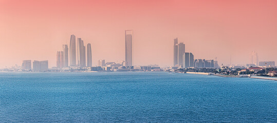 Abu Dhabi skyline glowing under a vibrant sunset