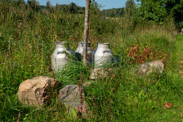 Vintage Milk Jugs in a Scenic Countryside Landscape