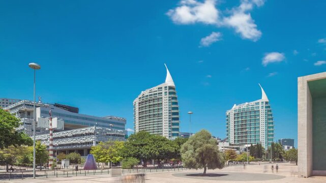 Parque das Nacoes (Park of Nations) in Lisbon timelapse hyperlapse. Modern Cultural Center And a Place For a Shopping Mall, expo Pavilions Buildings and Hotels. Walking alleys with green trees
