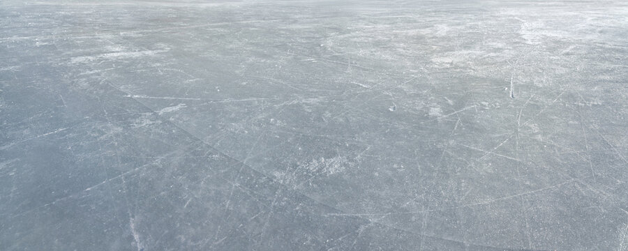  An ice surface as an ice rink with ice skates tracks. Winter sports texture. Big Panorama.
