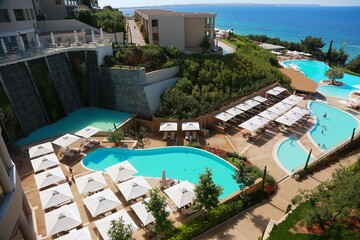 Luxurious Seaside Resort with Multiple Pools, Sun Loungers, and Umbrellas Overlooking the Ocean,...
