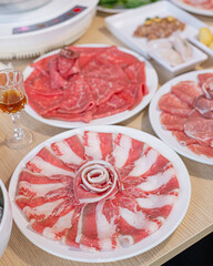 Delicious Assortment of Fresh Sliced Meat and Appetizers on White Plates - Perfect for Hot Pot or BBQ