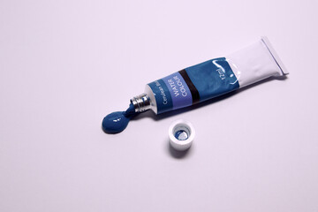 tube of paint squeezed out on a gray background, top view