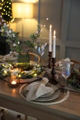 Christmas place setting with festive decor on wooden table in room