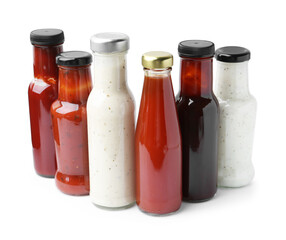 Different delicious sauces in glass bottles isolated on white