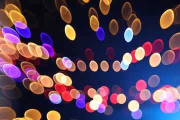 Blurred view of colorful lights on dark blue background, bokeh effect