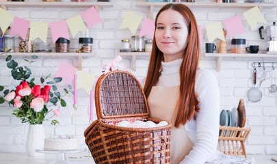 woman in apron holding basket with white eggs , getting ready for Easter