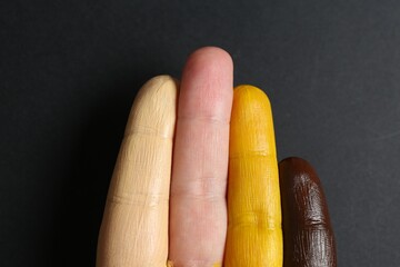 Stop racism. Woman with her fingers painted in different colors on black background, top view