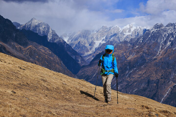Backpacking woman hiking on high altitude mountain top