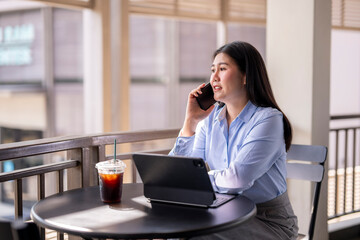 A woman is sitting at a table with a laptop and a cup of coffee