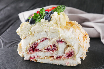 beautiful delicious crispy meringue roll on a dark rustic background