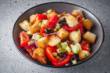 delicious traditional Italian panzanella salad on a stone rustic background