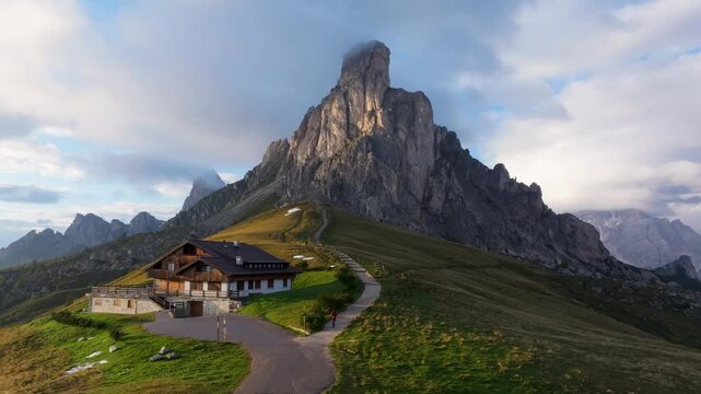 Aerial view of passo giau with a person hiking among majestic mountains and serene valleys, Colle Santa Lucia, Italy.