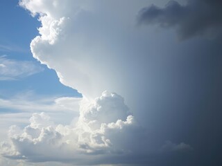 Tall dark cumulonimbus clouds dominate the blue sky, anvil shaped cloud formation, heavy precipitation, atmospheric conditions