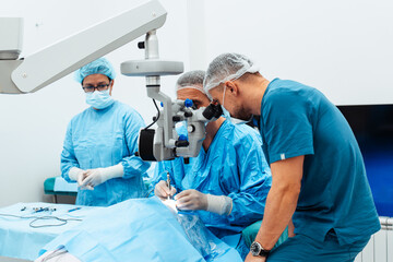 Skilled surgeon and his medical team performs precise eye surgery on an elderly patient, restoring vision with latest medical technology and cutting-edge techniques. Modern eye surgery concept.