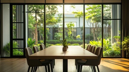 Obraz premium Professional meeting room setup with a polished wooden table, glass dividers, and expansive windows overlooking a garden.