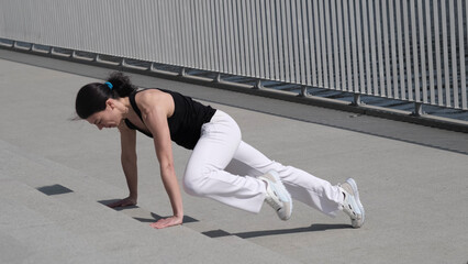 A fit woman engages in a high-intensity workout, executing mountain climbers with precision. The...