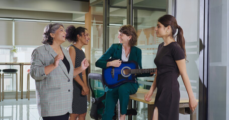 Indian Asian happy young adult girl hold guitar play music make fun joy job office place old aged boss lady crazy teen female multi staff group team do dance sing song spend time enjoy work break