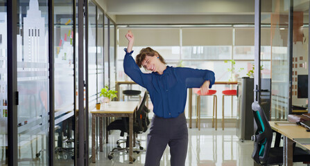 Happy joyful young adult gen z woman lady dancing on music indoor office have fun joy enjoy job...