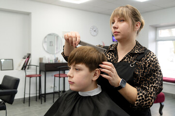 Masterful hairstyling in a modern salon as a young boy gets a fresh haircut on a bustling afternoon