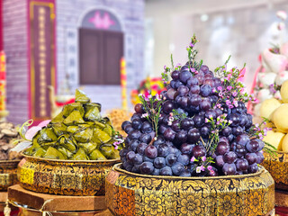 Preparing of fruits for offering. Grape and sticky rice steamed with banana leaf. Chinese style.