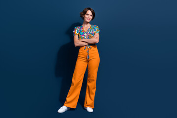 Fototapeta premium Full size photo of attractive young woman crossed hands confident pose dressed flared pants clothes isolated on dark blue color background